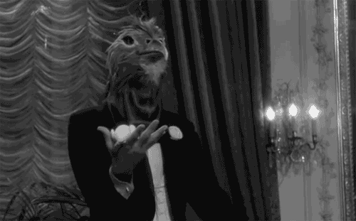 The same GIF of a stage magician wearing an anatomically accurate chicken mask.