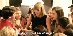 GIF of Taylor Swift handing out cookies to her fans.