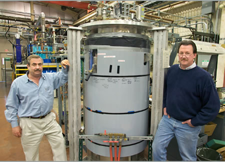 Scientists Caspi and Gourlay stand next to their 16-Tesla magnet after breaking the world record in 2004, picture from Lawrence Berkley Laboratory